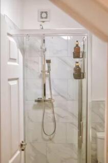 A modern bathroom featuring a sleek glass-enclo...