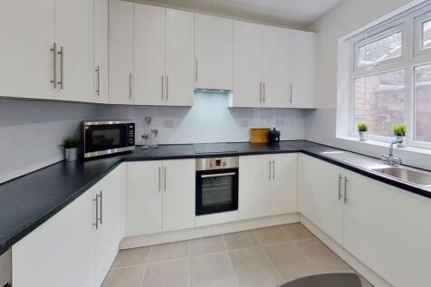 Bright and modern kitchen with ample white cabi...