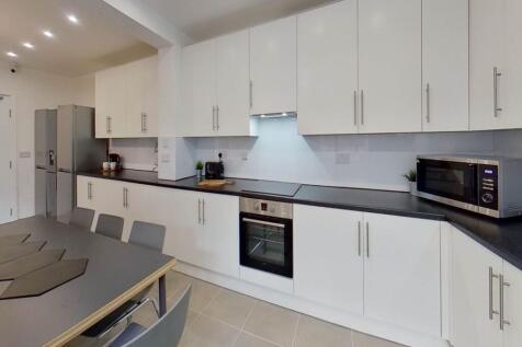 Bright and modern kitchen with ample white cabi...