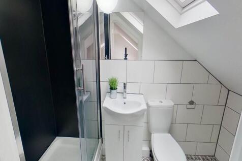 A modern bathroom with clean white tiles, a com...
