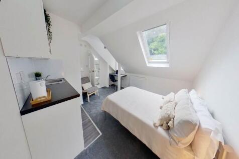 Bright and cozy single bedroom featuring a comf...