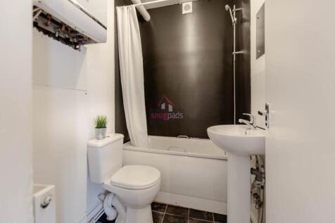 A modern bathroom featuring a white bathtub wit...