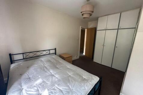 A bright double bedroom featuring a large bed, ...