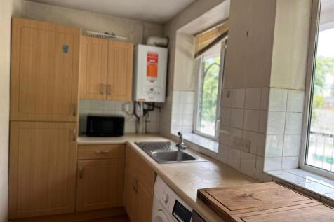 Bright kitchen area featuring wooden cabinetry,...