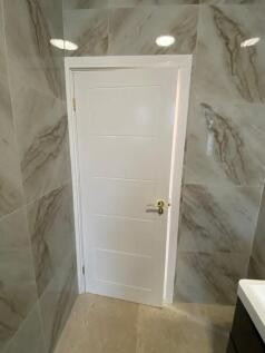 A modern bathroom featuring a clean, white door...