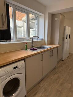 Bright and tidy kitchen area featuring a wooden...