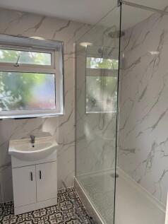 A modern bathroom featuring a walk-in shower wi...