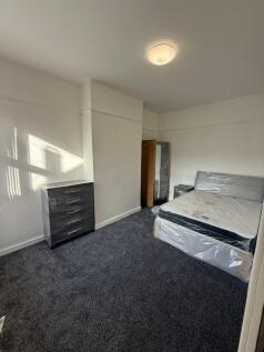 A tidy, simply furnished bedroom highlighted by...