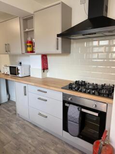 Modern and clean kitchen featuring white cabine...