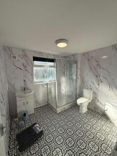 Modern bathroom featuring a glass-enclosed show...