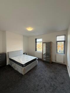 A bright and clean bedroom featuring a comforta...