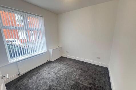 Bright and tidy bedroom with a large window all...
