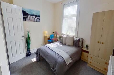 A well-lit bedroom featuring a comfortable doub...