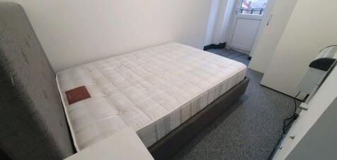 A clean single bed/mattress in a small, well-ma...