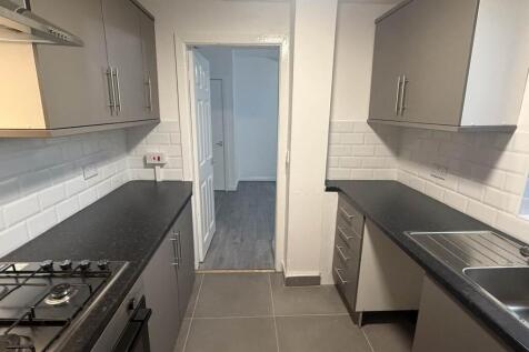 A modern, clean kitchen with ample workspace, w...
