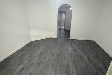 A bright, clean bedroom with modern flooring an...