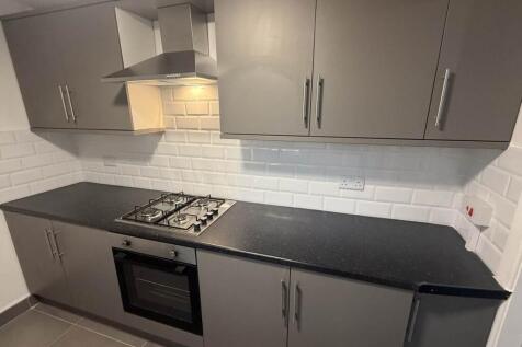 A modern kitchen featuring sleek gray cabinets,...