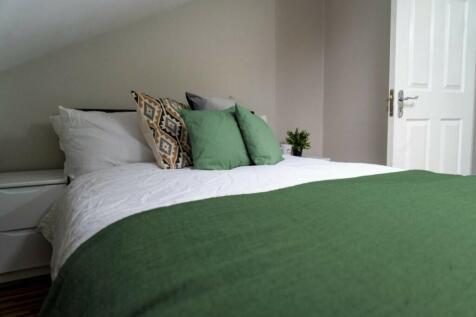 A spacious, well-presented bedroom featuring a ...