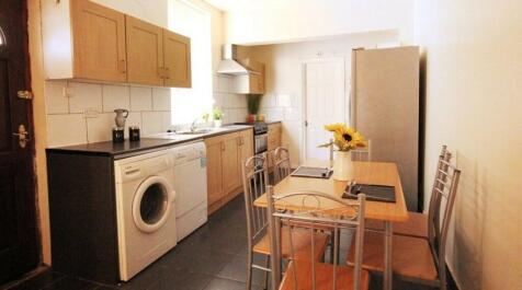 A well-lit kitchen area featuring a compact arr...