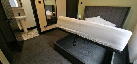 A compact bathroom with a raised bed frame, whi...