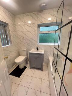 A clean and bright bathroom featuring a toilet,...