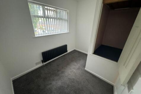 A tidy, well-maintained small bedroom with a wi...