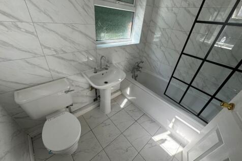 A bright and modern bathroom featuring a bathtu...
