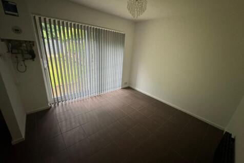 A bright and airy bedroom with vertical blinds ...