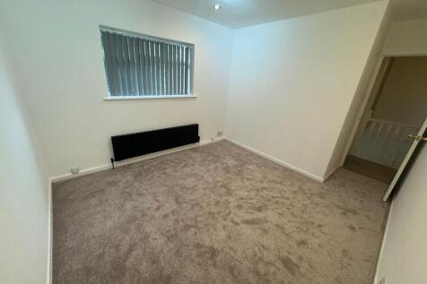 A modest single bedroom featuring a neutral col...