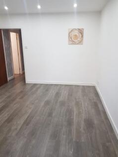 A simple, clean room with neutral white walls a...
