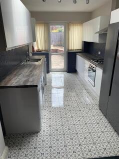 Modern galley kitchen with patterned tiled floo...