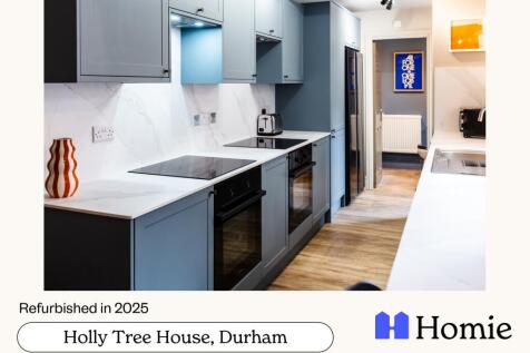 Bright modern kitchen with sleek grey cabinets,...