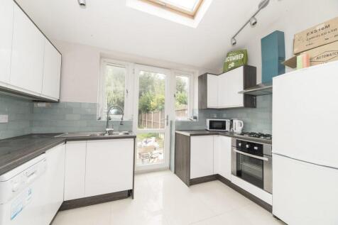 Bright modern kitchen with white cabinetry, int...