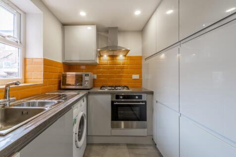Bright modern galley kitchen with glossy cabine...