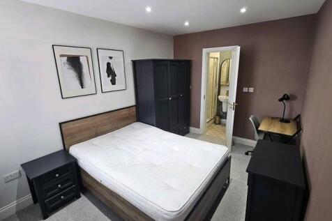 A modern master bedroom featuring a comfortable...