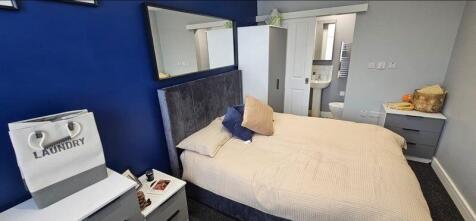 A stylish master bedroom featuring a comfortabl...