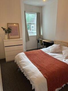 A bright and cozy double bedroom featuring a co...