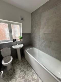 A bright, clean bathroom featuring a white toil...