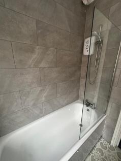 Modern bathroom featuring a clean white bathtub...