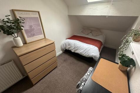 A cozy and well-maintained double bedroom with ...