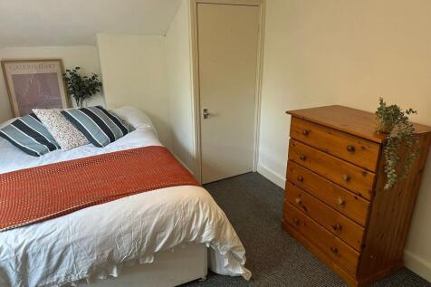Cozy and inviting double bedroom featuring a co...