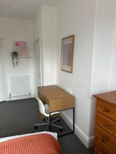 A neatly maintained bedroom with a study desk, ...