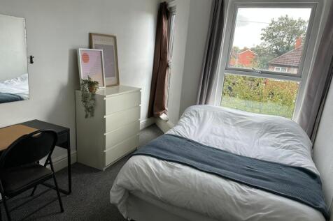Bright and cozy bedroom featuring a large windo...