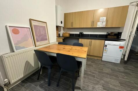 A modern, clean kitchen with wooden cabinets, b...