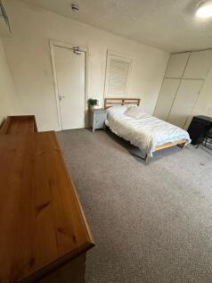 A cozy and simple single bedroom featuring a wo...