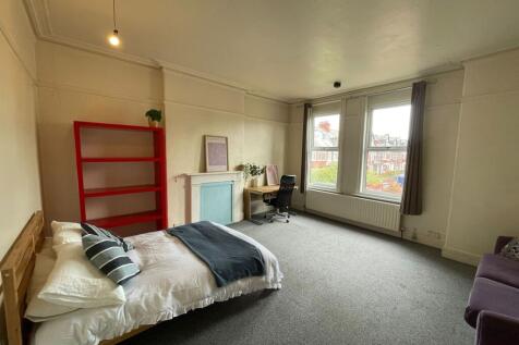 A spacious and well-lit living area with large ...