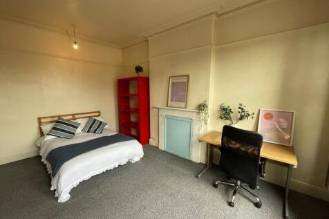 Bright and cozy bedroom featuring a neatly made...