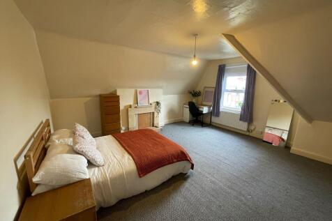 A spacious and inviting bedroom featuring a com...