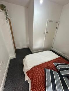 A cozy double bedroom featuring a neatly made b...