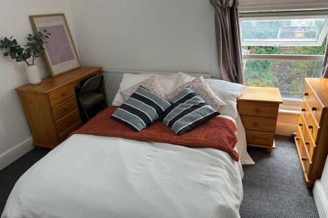 Spacious and welcoming bedroom featuring a comf...